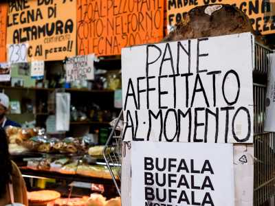 ...dove diversi cartelli colorati recitano �pane affettato al momento� o �bufala e mozzarella a chilometro zero�
